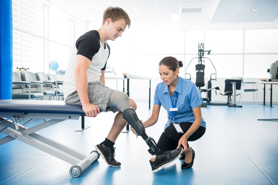 Decorative image of a physiotherapist helping a young man with prosthetic leg.