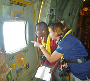 Two people look out through the window of a plane