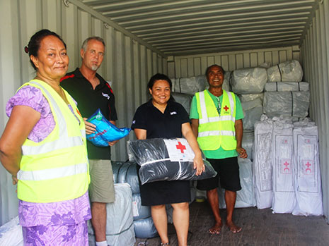 People standing in a shipping container with supplies.