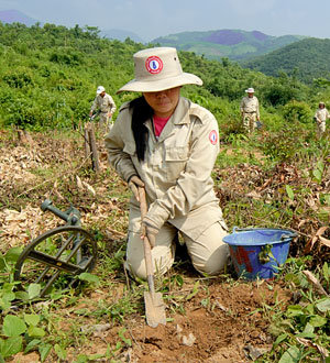 Woman digging for unexploded ordnance