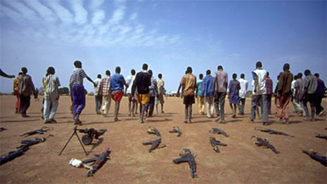 Guns laying on the ground as a group of boys walk away from them