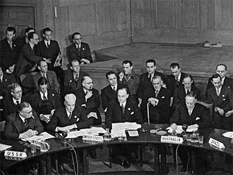 Men in suits sitting around a curved table