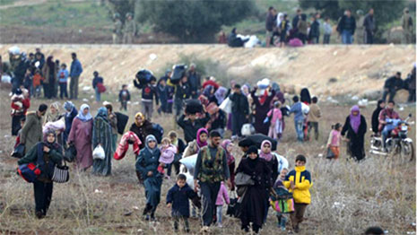 People walking through fields carrying their belongings