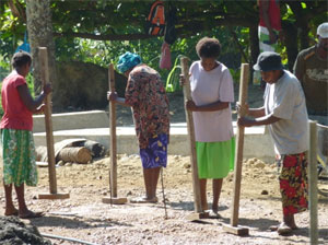 Photo of a 4 woman manually compacting gravel road