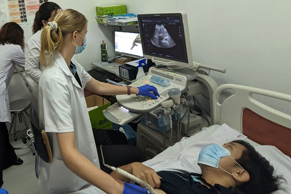 Photo of sonography student conducting a sonogram on patient. 