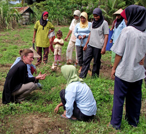 Anna talking with a group of women in a field