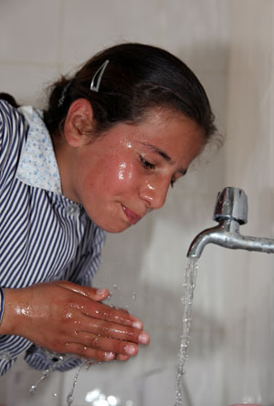 Girl washing face with clean tap water