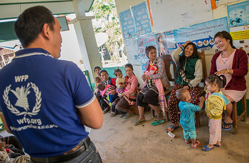Women and children listening to WFP representative