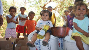 Children sitting on bags of wheat
