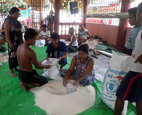 People filling sacks and boxes with food