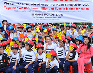 Actress Michelle Yeoh with Vietnamese children wearing bike helmets