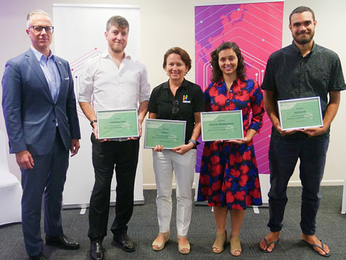 Photo of 5 people, four holding awards.