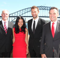 Photo of Craig Emerson, Ian Thorpe and Yeojin Bae standing in front of the Sydney harbour bridge